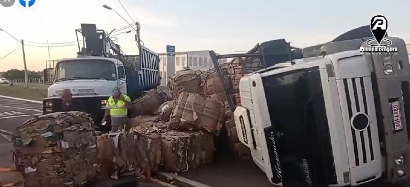 Caminhão carregado com papelão tomba em rotatória