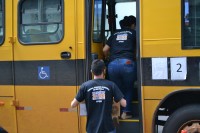 Funcionários dos cartórios levam as urnas até os ônibus que as transportaram para as escolas