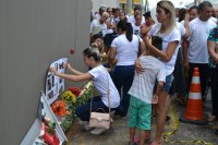 Flores, rosas, faixas e cartazes foram deixados no local