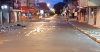 Lixo ficou todo espalhado pela rua; autor tentou se esconder atrás de uma árvore