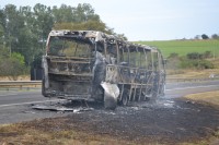 Micro-ônibus ficou totalmente destruído com as chamas; passageiros não se feriram