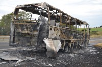 Micro-ônibus ficou totalmente destruído com as chamas; passageiros não se feriram