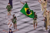 Ketleyn Quadros e Bruninho com a bandeira brasileira na abertura dos Jogos de Tóquio 2020